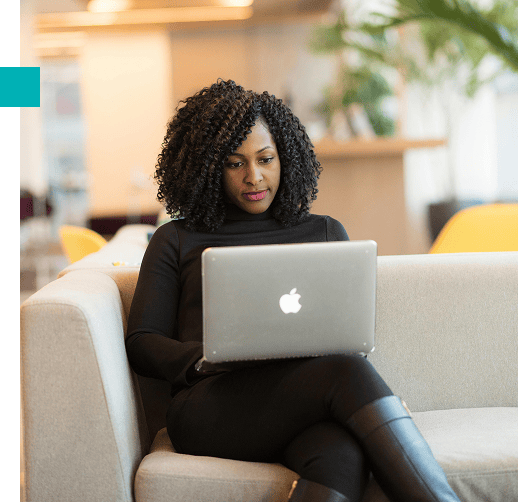 Black entrepreneur working on a laptop, advancing her business through digital resources and mentorship opportunities.