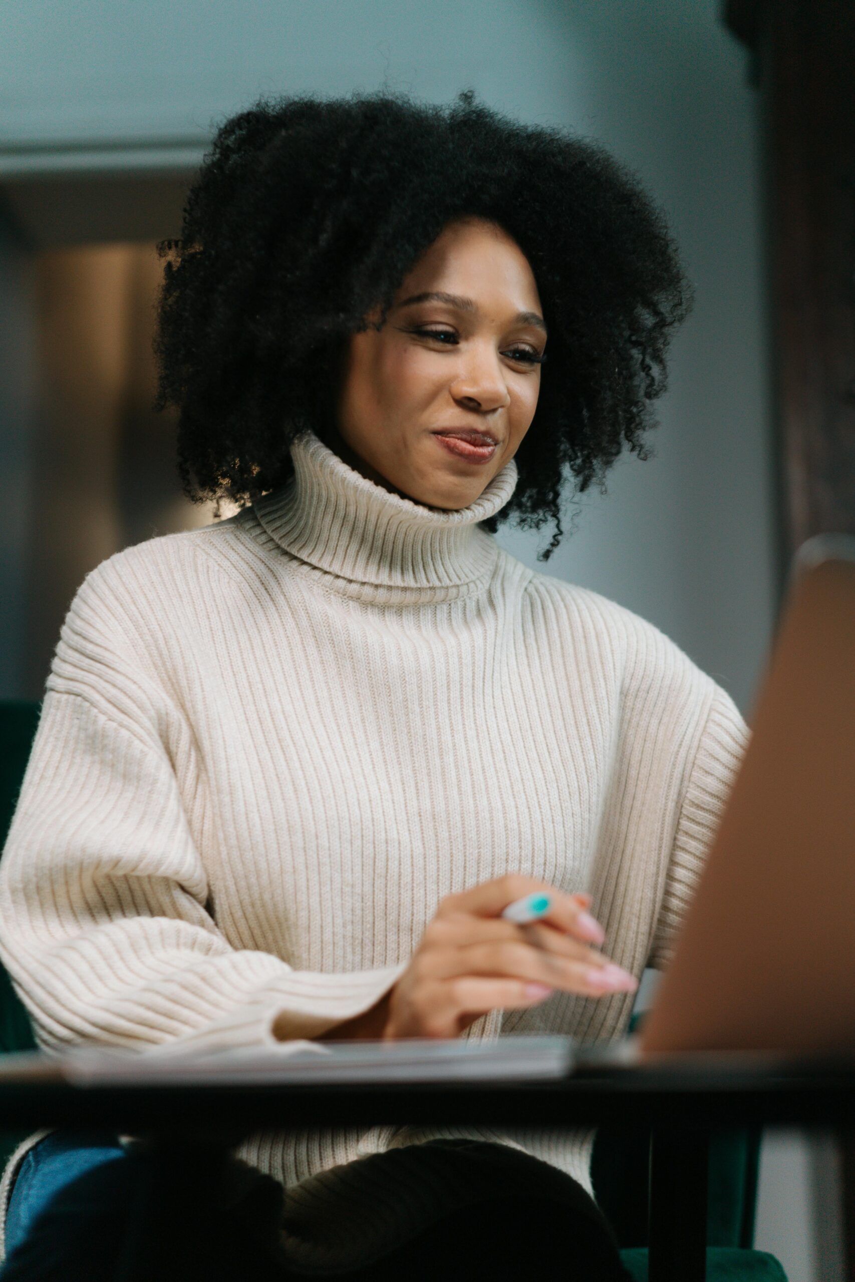 Black entrepreneur working on a laptop, advancing her business through digital resources and mentorship opportunities.